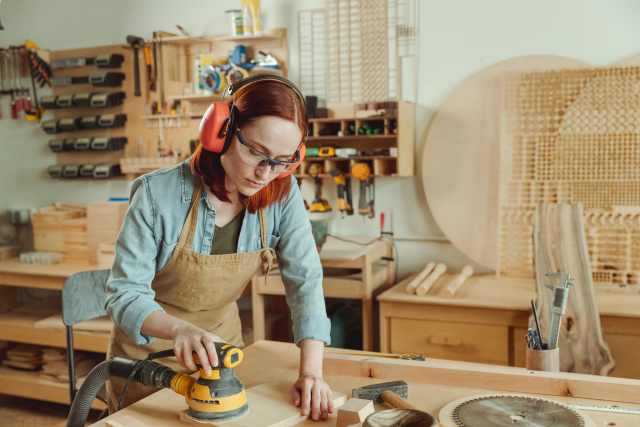 電動サンダーを使っている女性