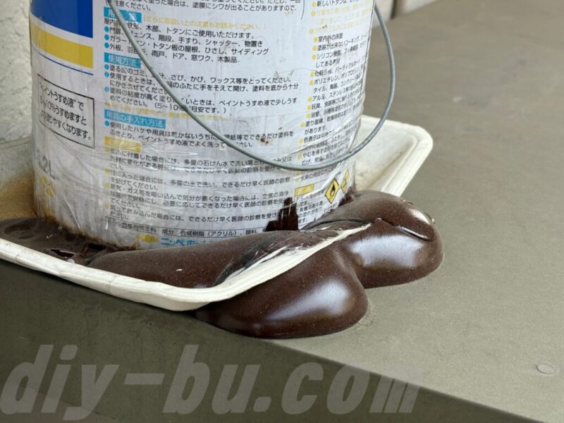 塗料缶の底に穴が開いて中身が漏れ出して物置の上が大惨事の様子