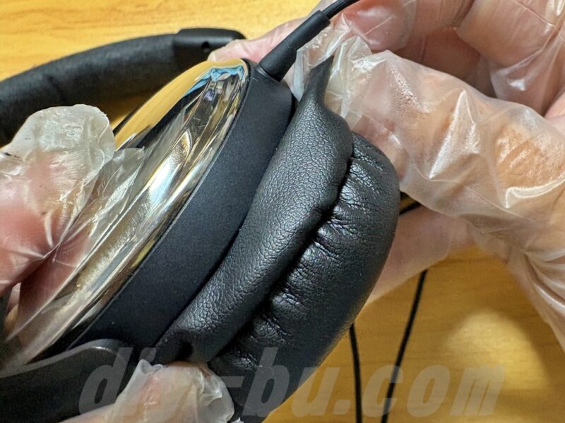 新しいイヤーパッドをヘッドホンに装着している手元
