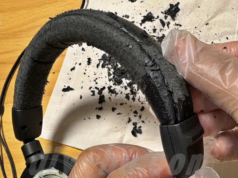 ヘッドバンドカバーを装着する前に、劣化したヘッドバンドを手で揉んで劣化した合皮を剥がしている様子