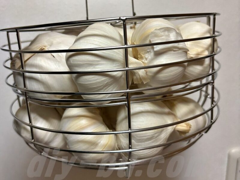 黒ニンニクメーカーのカゴに丸ごとのにんにくを並べた様子